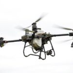 Een drone met thermische camera inspecteert een nutsvoorziening in de lucht, met duidelijke warmtemapping.